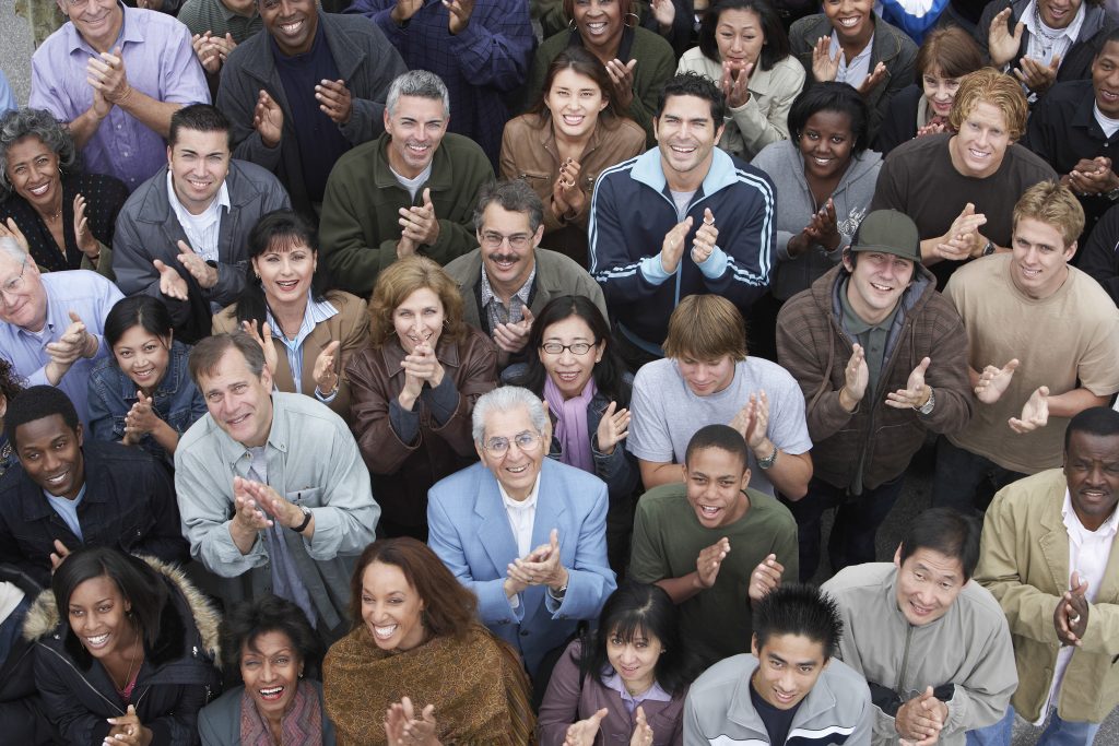 A group of people clapping in front of each other.
